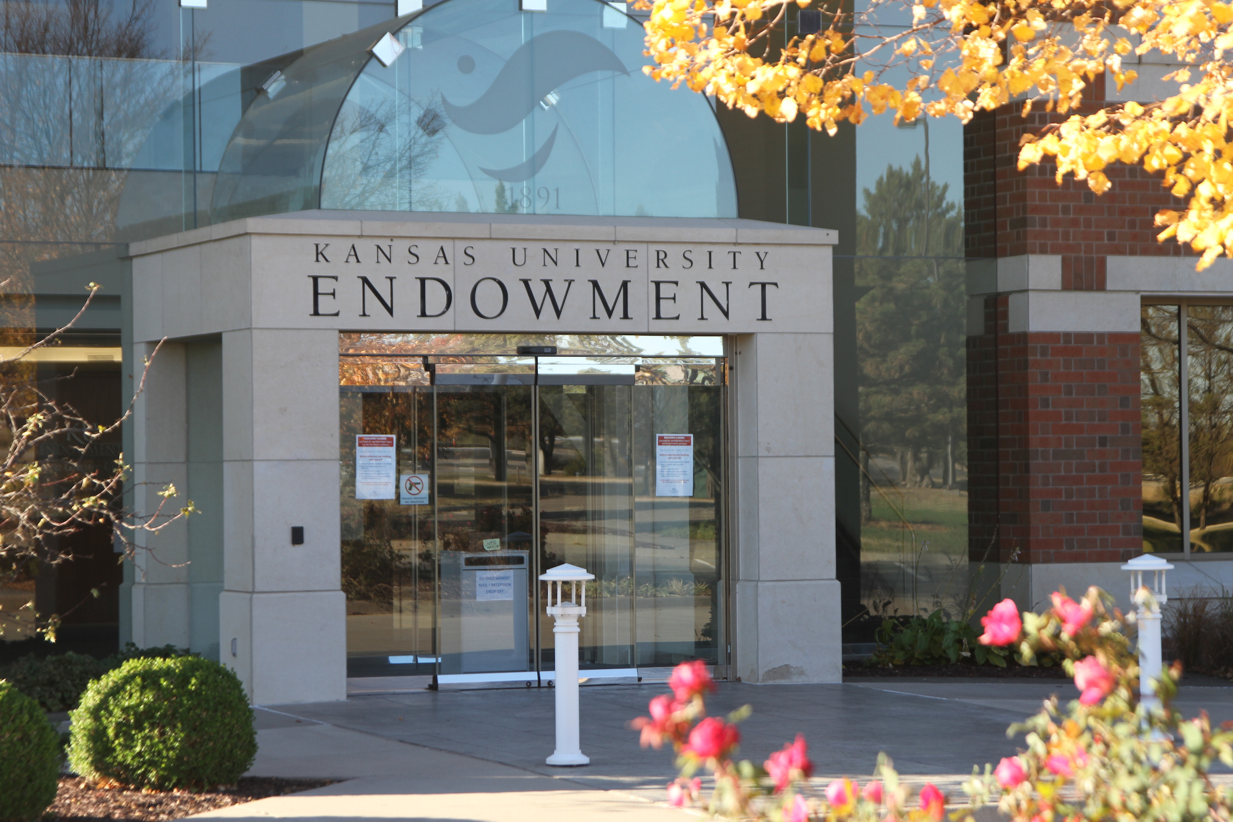 KU Endowment building exterior, Nov. 3, 2020. Building is currently closed to the public due to COVID-19 prevention measures. Hence the signage on the front door and the drop box inside the first double door.