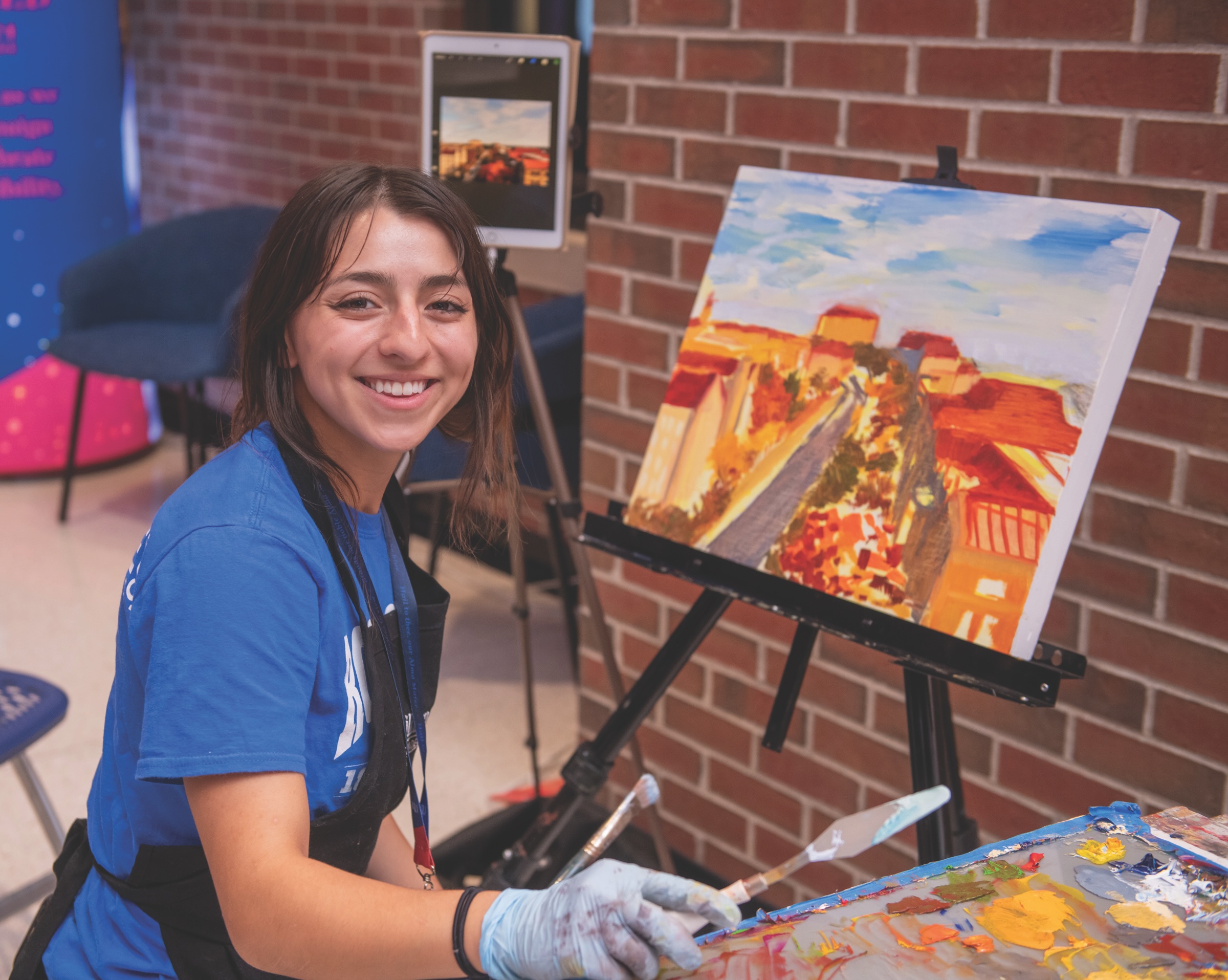 TALENT ON DISPLAY:
KU Painting Club President Octavia Lawson-Solorio paints a familiar campus scene live at the event. Attendees could enter a raffle to take the completed piece home.